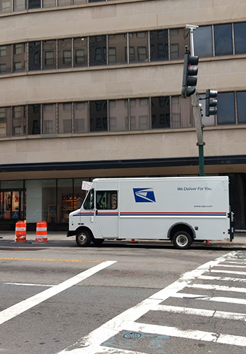 USPS truck delivering mail to a digital mailroom location