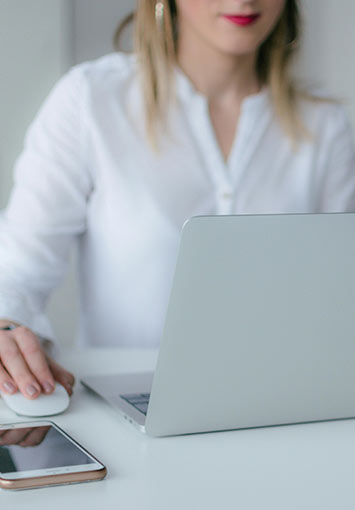 Woman Uses Computer At Her Desk